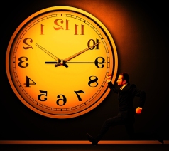 serious running businessman and big white clock in dark room
